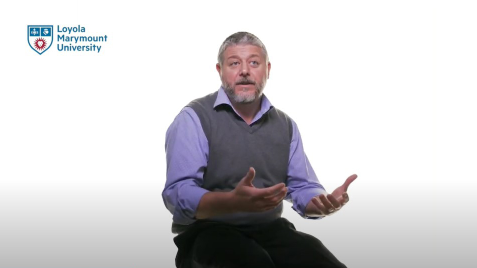 LMU Accounting Clinical Associate Professor Anthony Menendez sitting on a stool in front of a white background.